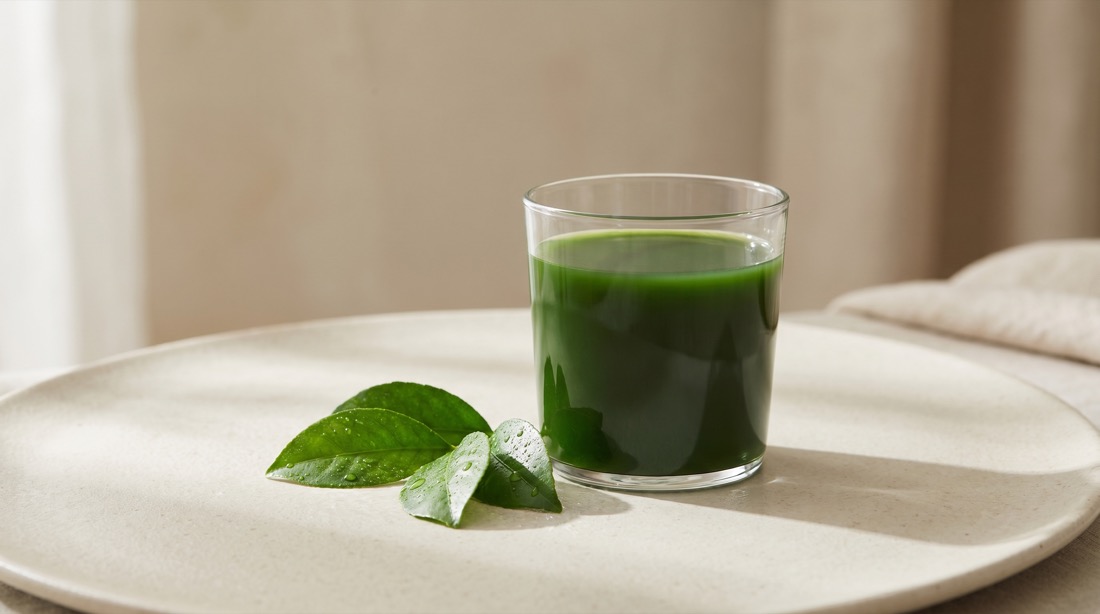 Glass of liquid chlorophyll with fresh leaves